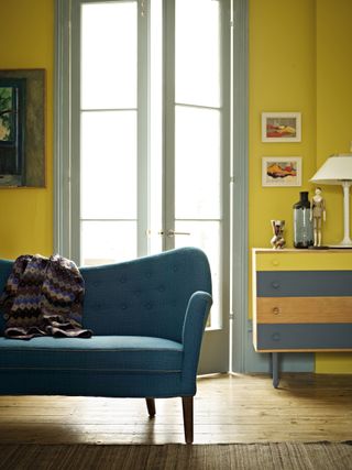 yellow living room with blue sofa and french doors