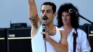 Freddie Mercury står på scenen med mikrofonen i högsta hugg i filmen Bohemian Rhapsody