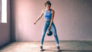 Woman performing a single-arm kettlebell swing