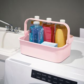 Pink under sink storage caddy filled with cleaning products