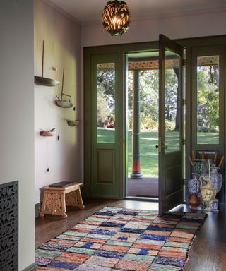hall with open door to garden and patchwork rug