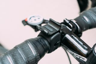 An empty black clamp on a set of handlebars to hold a bike light