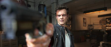 Jack Quaid as Nathan holding a gun in Novocaine