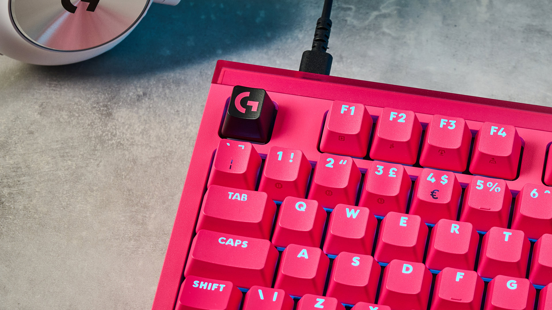 A photo of the Logitech G Pro X2 Rapid keyboard in hot pink on a stone surface