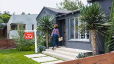 Female real estate agent carrying document while walking into house