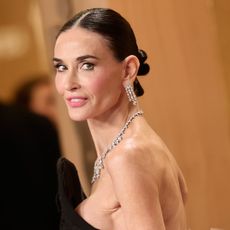 a white woman with dark hair poses for photos during an awards show