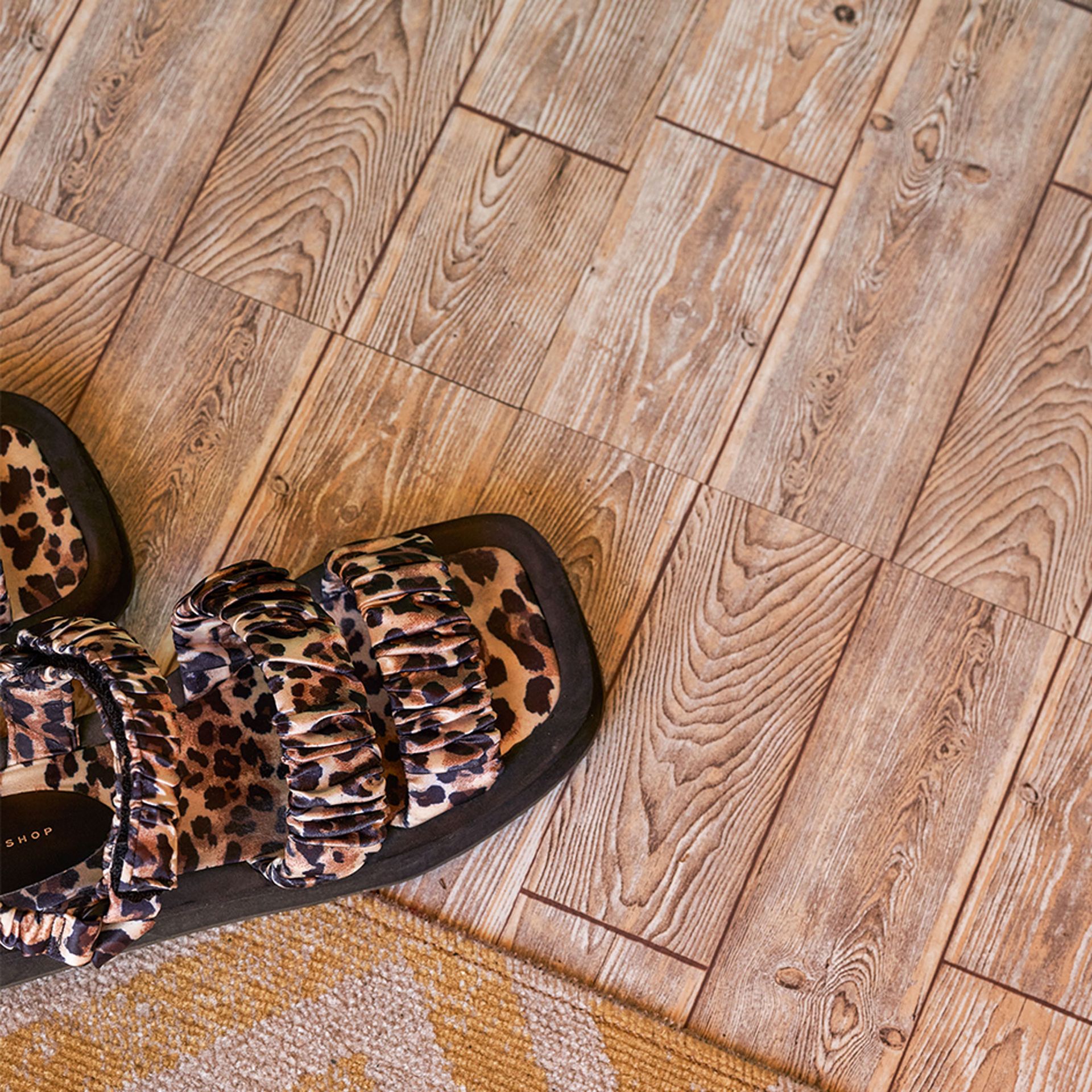 Malowana na pomarańczowo chatka plażowa z płytkami podłogowymi imitującymi drewno