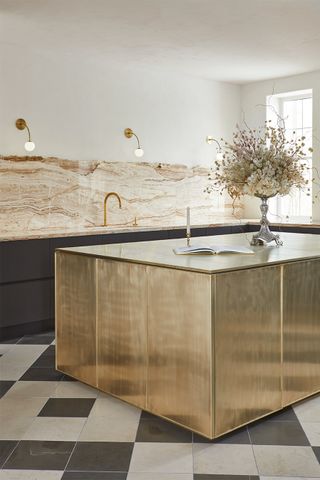 modern kitchen island covered in brass on the sides and counter
