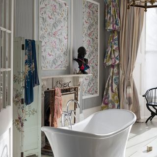 bathroom with freestanding bathtub and striped wallpaper