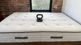 Avocado Green Mattress with kettlebell on top, testing pressure relief
