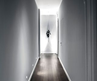 narrow modern white hallway with low level lighting