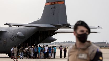 Afghan refugees queue to board a US military plane