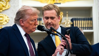 President Donald Trump looks at photo on Fox News correspondent Peter Doocy's phone