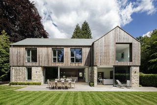 barn style house with modern glazing and lawned garden