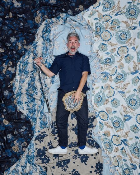 David Nicholls lying on a bed of fabrics