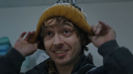 Resident Evil (2026) trailer still - Austin Abrams pulling on a touque