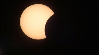 The total solar eclipse of 2015 begins as the moon appears to take a bite out of the sun in this view from Longyearbyen, Svalbard provided by NRK News.