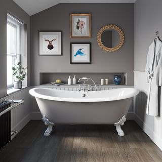 grey toned bathroom with grey freestanding bath and small gallery wall