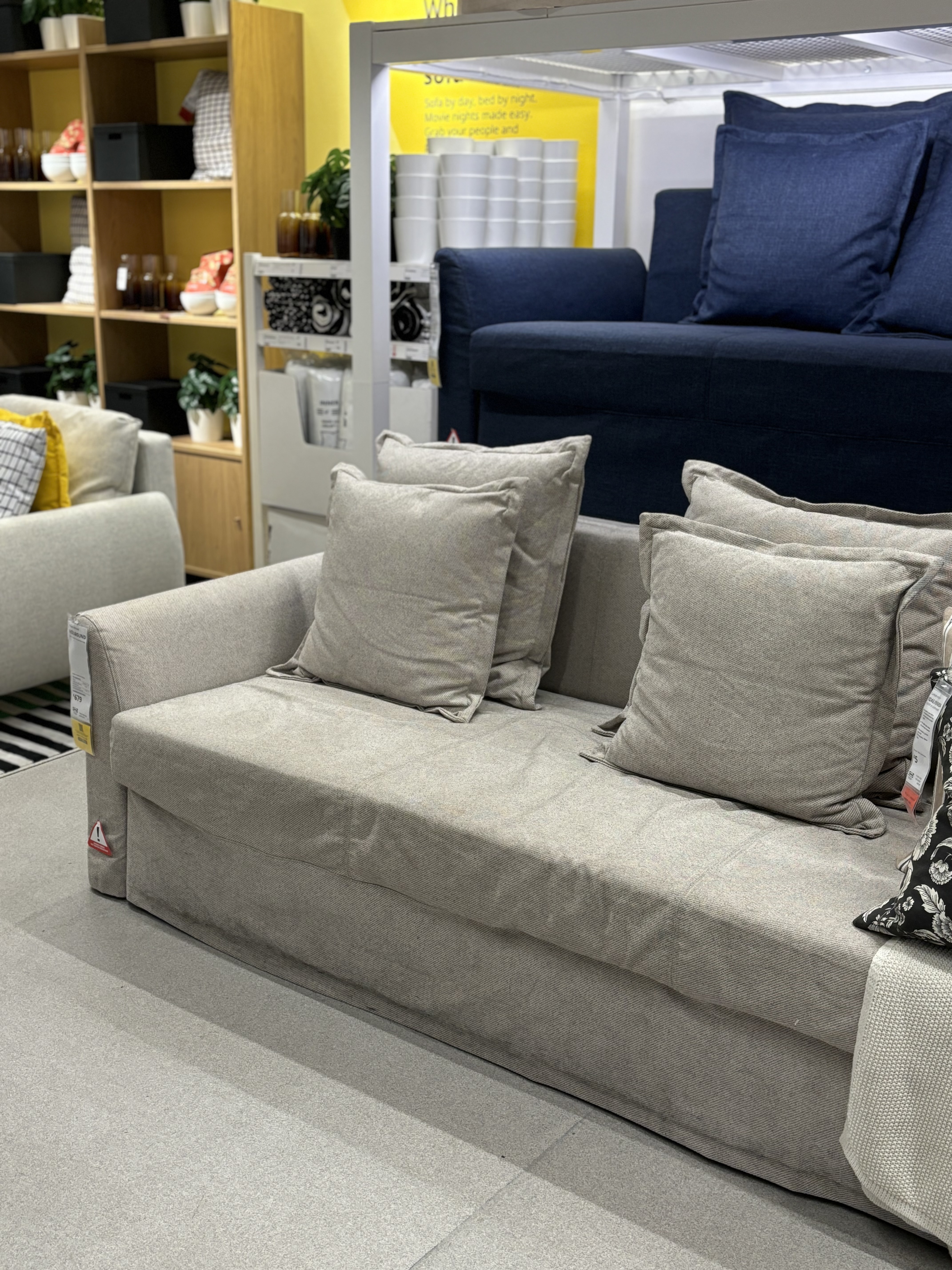A tan linen sleeper sofa sitting in a showroom