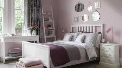 A cosy bedroom in purples and pinks with lavish curtains