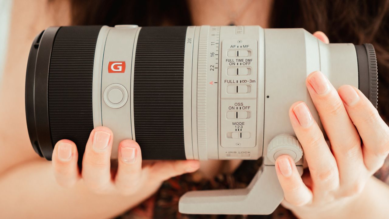 Sony FE 70-200mm f/2.8 GM OSS II lens held in the reviewer's hands.