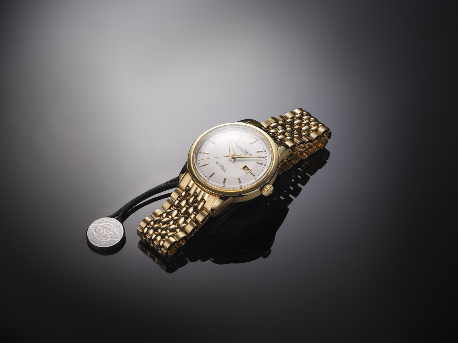 gold and silver IWC watch on a black background