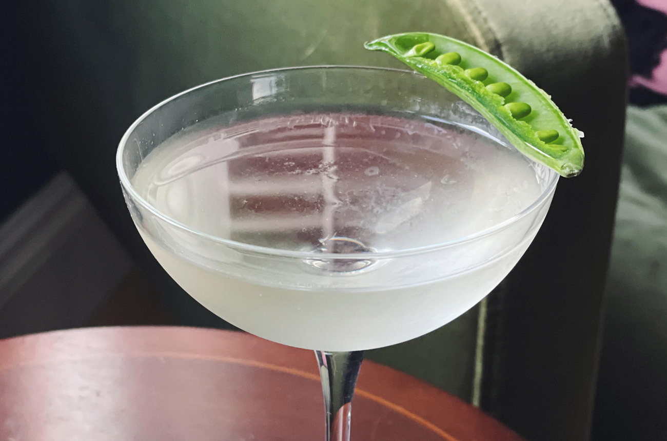 Martini cocktail glass with a pea pod