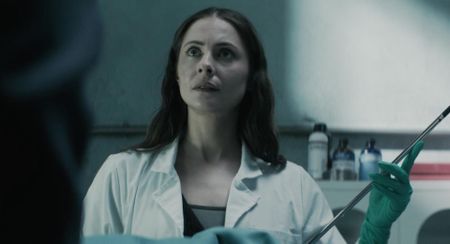 Willa Holland as Rebecca Owens in The Mortuary Assistant, holding a long needle