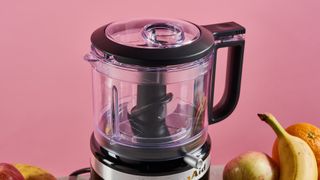 A close up of the work bowl and lid of the KitchenAid Mini Food Chopper, showing the spout and drizzle basin.