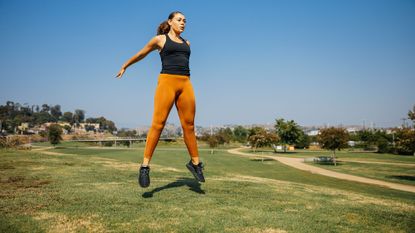 Plyometrics workout challenge: woman doing jumping exercises in a park