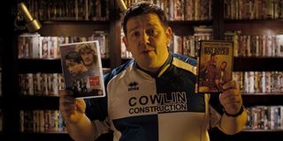 Nick Frost in Hot Fuzz holding DVDs