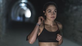 best running bra: woman running in tunnel