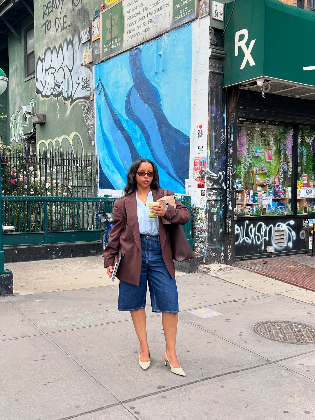 @aysha.sow wears a relaxed brown blazer, denim Bermuda shorts, a baby blue shirt and cream slingbacks