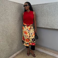 Woman wears red tank top, floral skirt, black heels