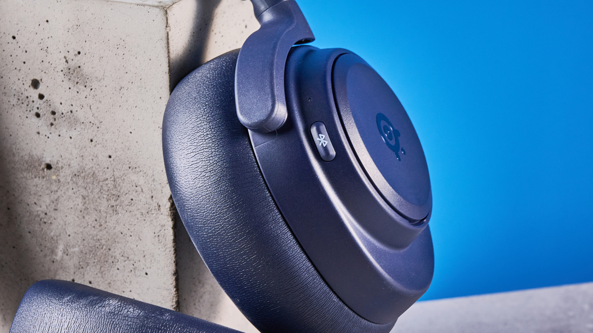 The SteelSeries Arctis Nova Pro Omni on a stone surface against a blue background