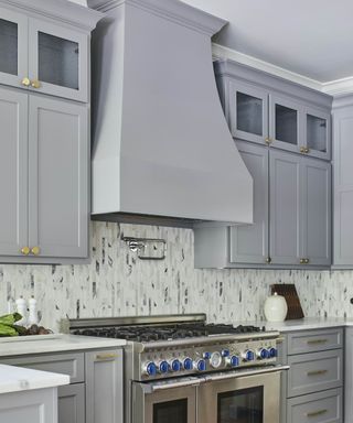 gray kitchen with large canopy cooker hood and steel range cooker