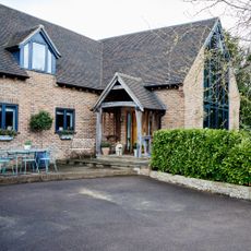Tarmac driveway leading up to home with large porch and dormer window