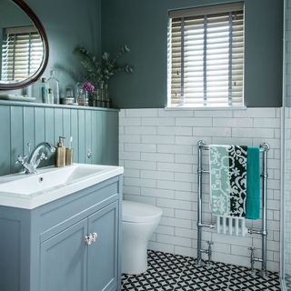 dark green walled bathroom with patterned black and white flooring