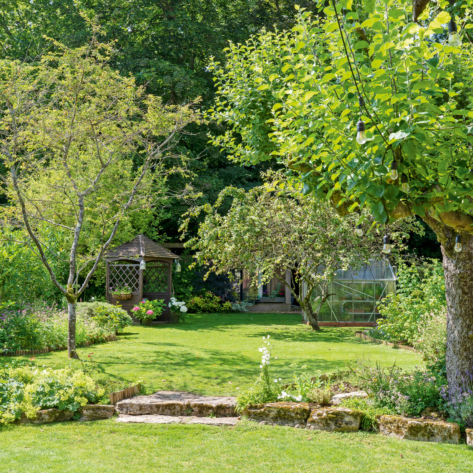 a large stepped garden with lawn, bower and greenhouse