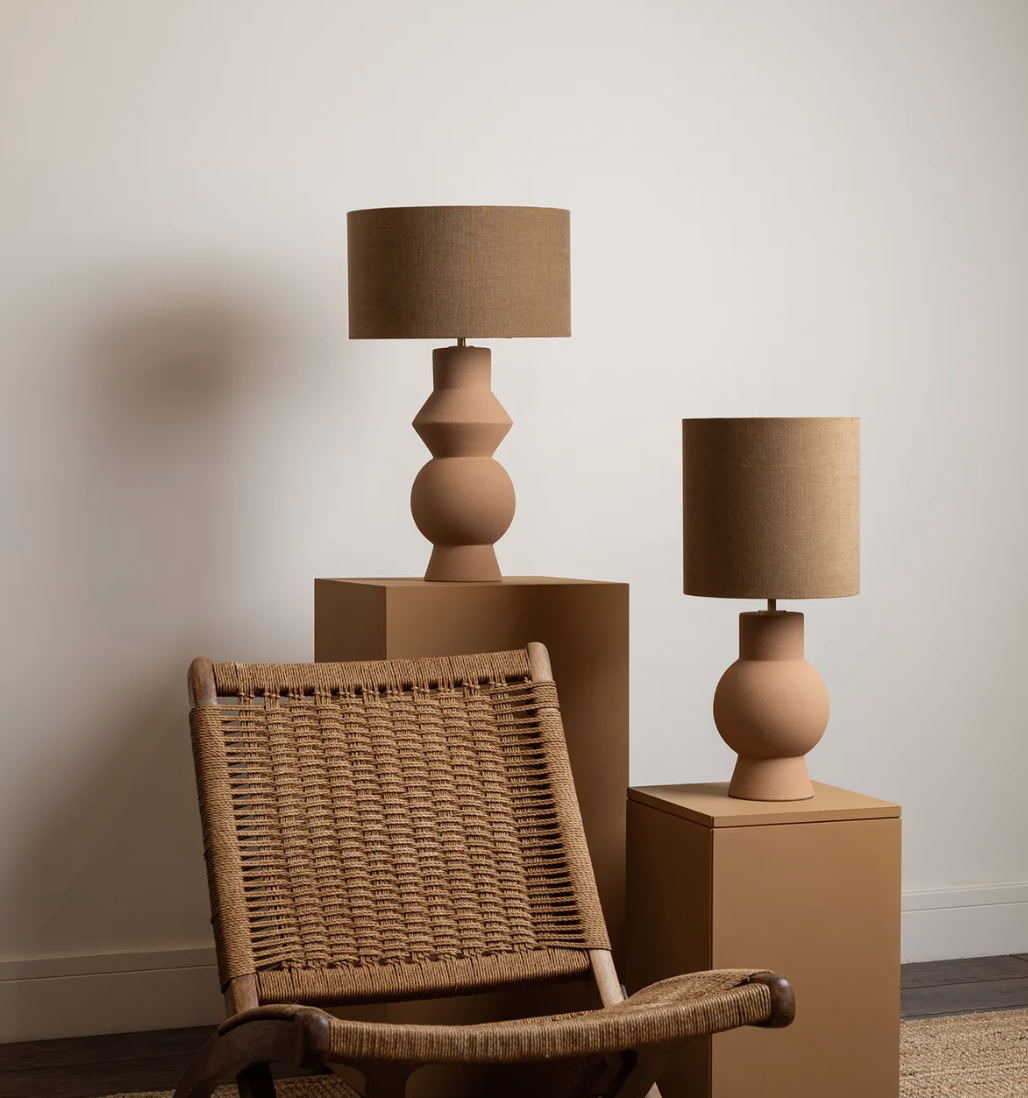 terracotta lamps on stands next to a rattan chair