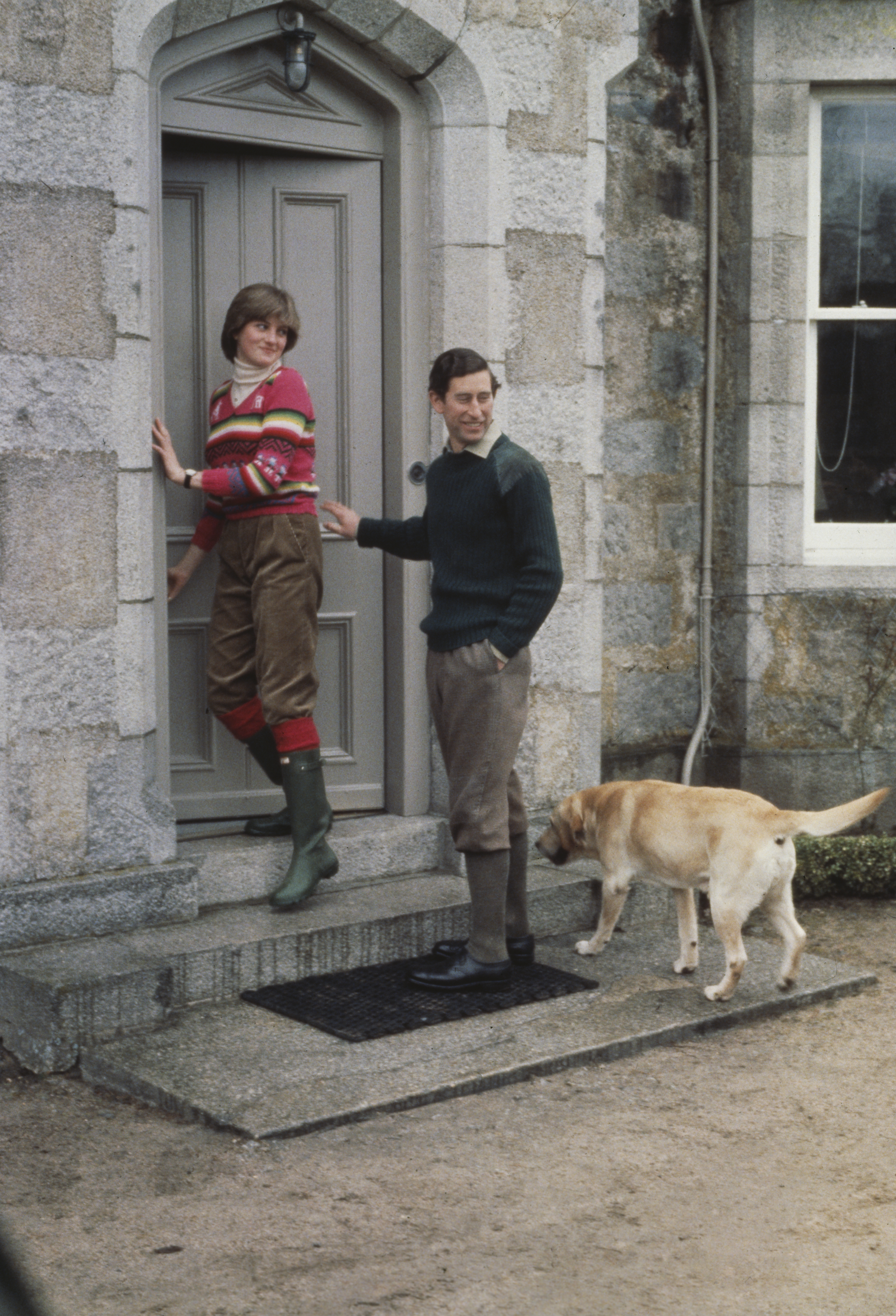 Princess Diana opening the door to Balmoral Castle with Prince Charles and his dog behind her