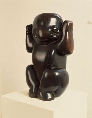 Hardwood sculpture of infant child.