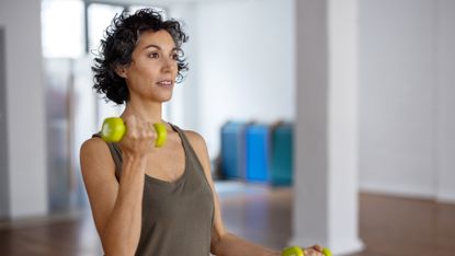 Woman working her upper body with a set of dumbbells