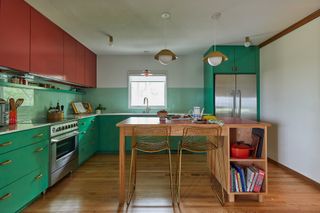 a green and red kitchen with an island
