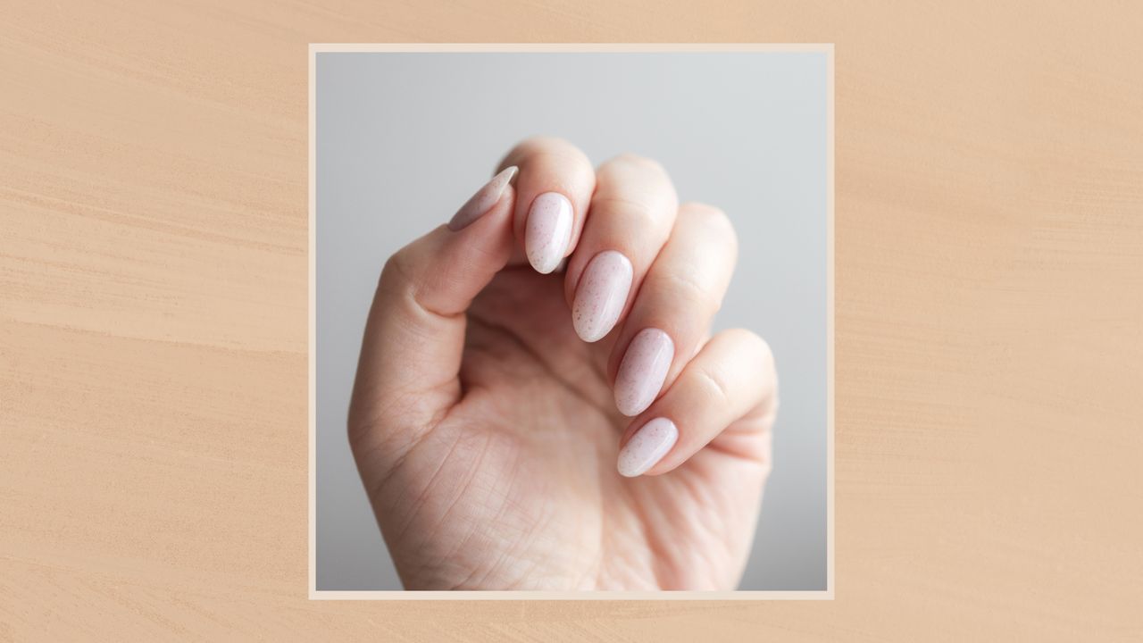 Image showing a close up of a pale pink manicure, in a frame against a warm beige watercolour-style background