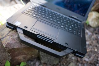 A black Dell Latitude 7330 Rugged Extreme laptop sitting on a rocky surface