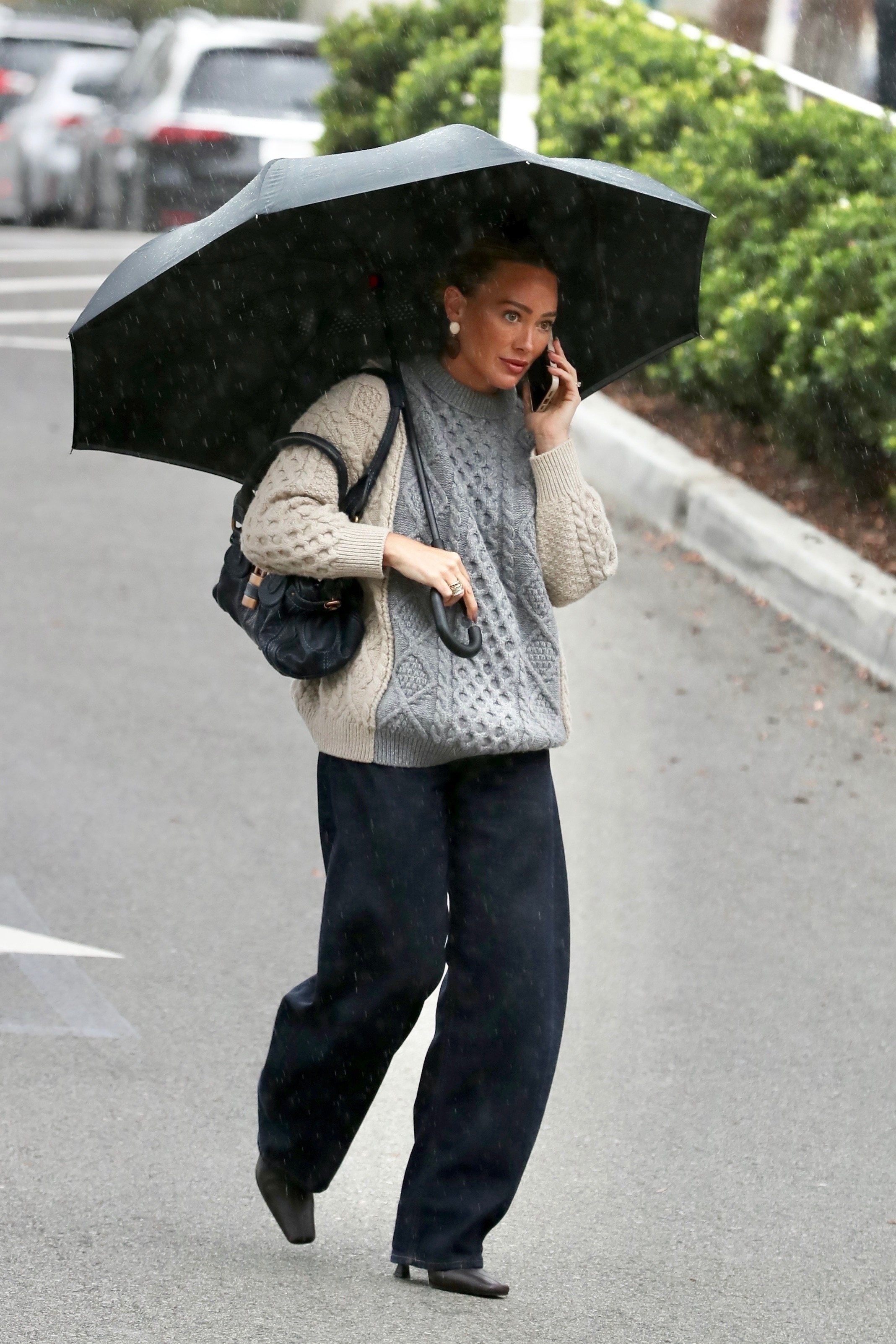 Hilary Duff wears black boots with a knit sweater