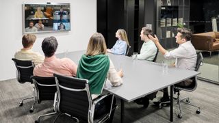 People in a conference room on a video call using Zoom-certified LG hardware.
