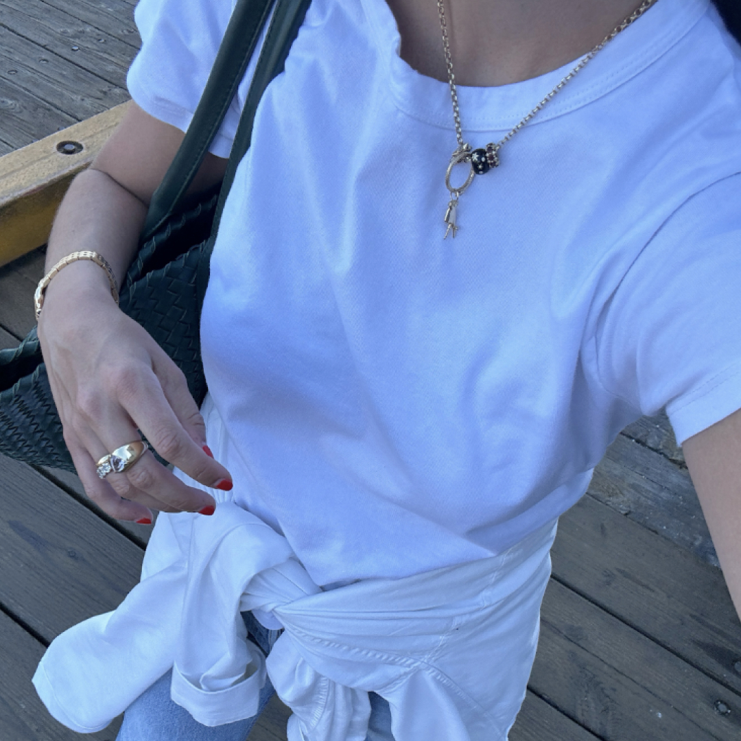 Rachel Whitehouse wears a white t-shirt and gold jewelry 