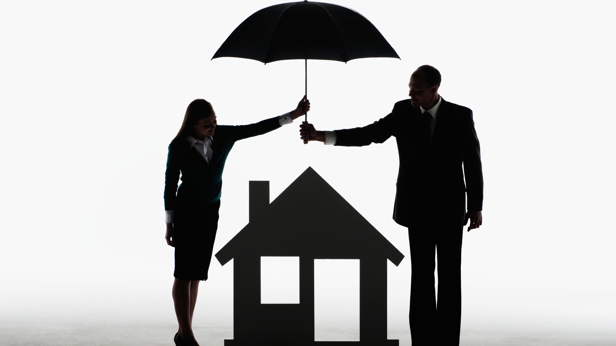 Couple holding an umbrella over a house